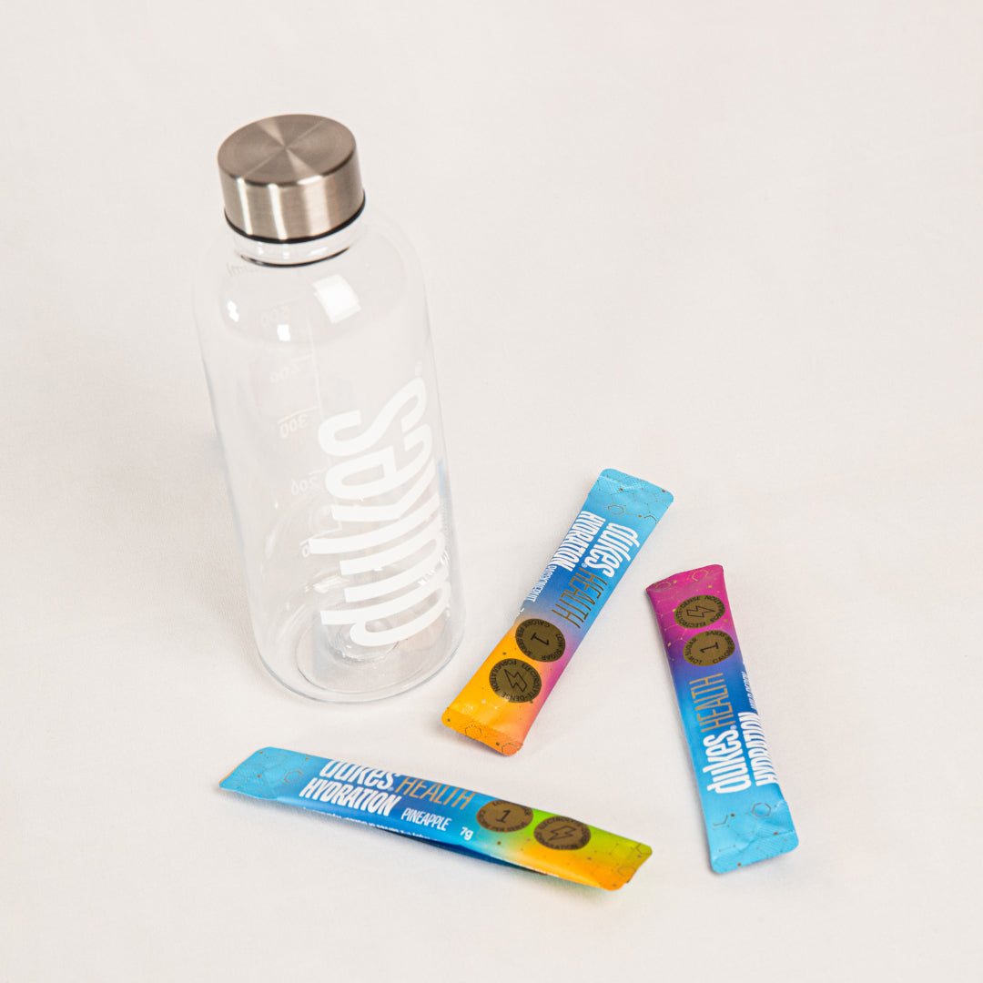 A top down perspective shot of the Dukes Hydration Bottle with some sachets of Dukes Hydration mix around it.